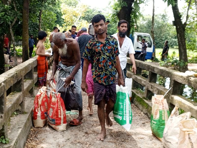 নোয়াখালীর সোনাইমুড়ী উপজেলার মুহুরিগঞ্জে ত্রাণ নিচ্ছেন বন্যার্ত্র। প্রথম আলো ট্রাস্টের উদ্যোগে এখানে ত্রাণ বিতরণ করা হয়। আজ দুপুরে